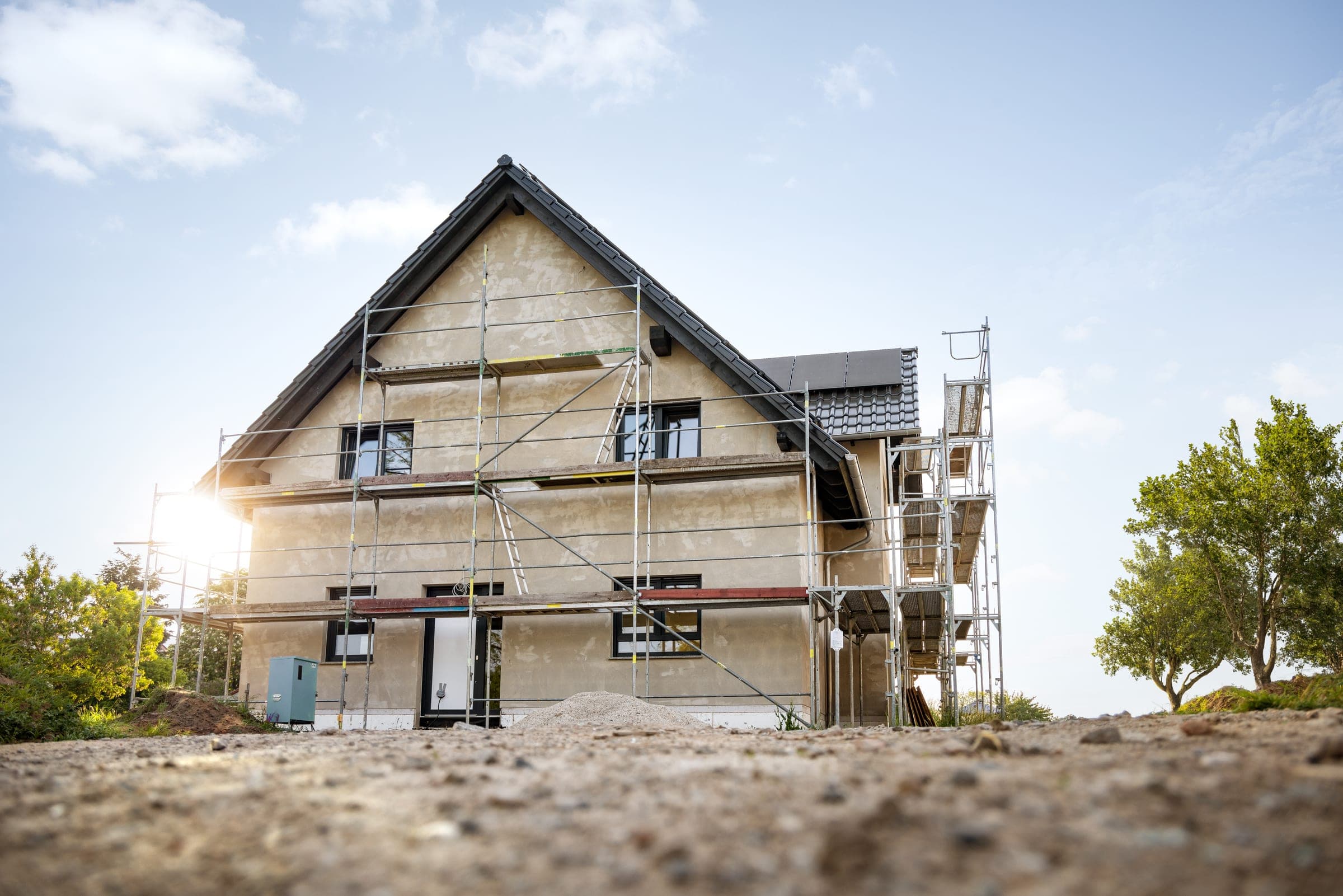 Maison d’habitation en construction avec échafaudage et façade enduite