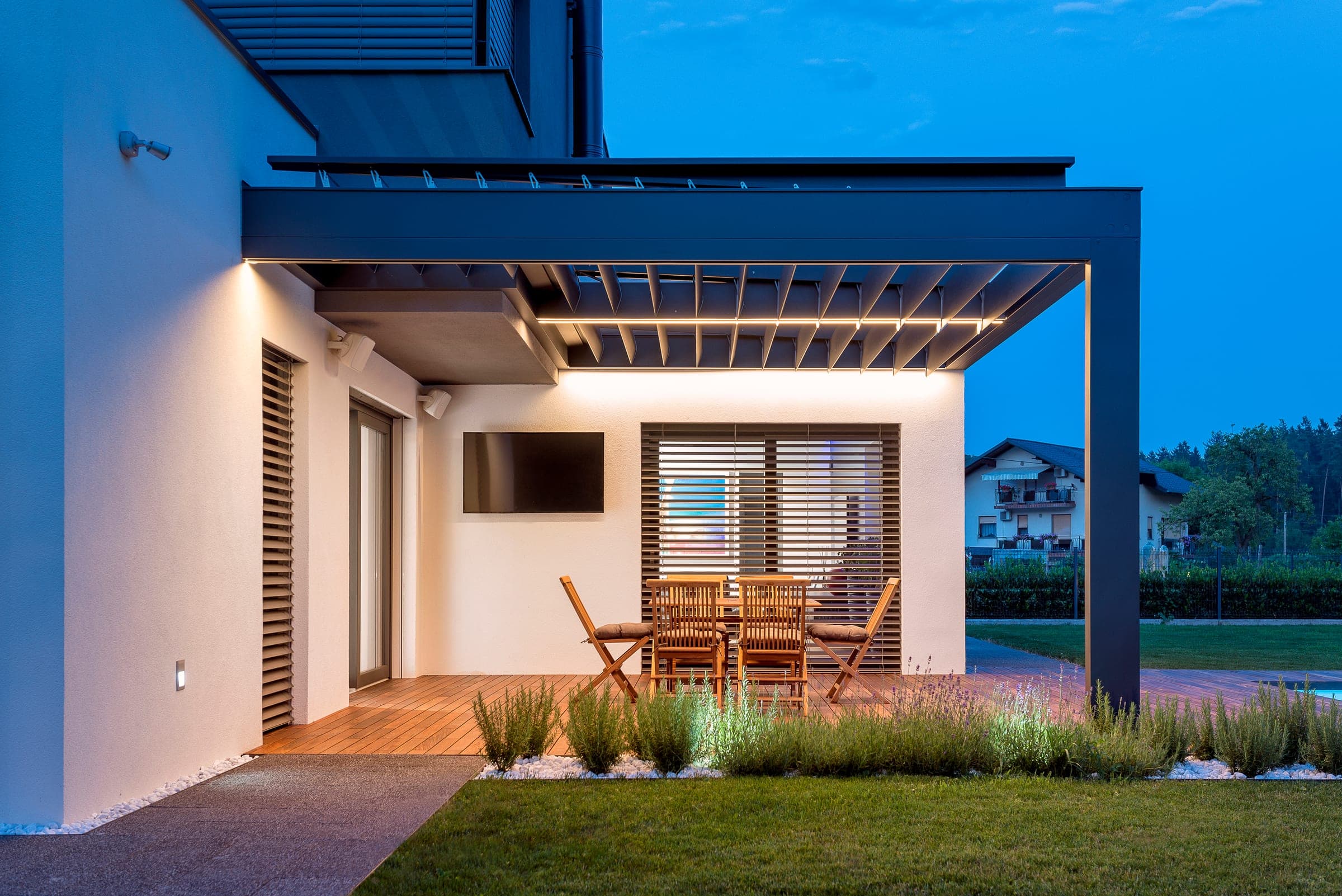 Modern house at dusk with exterior sun protection and a louvred roof