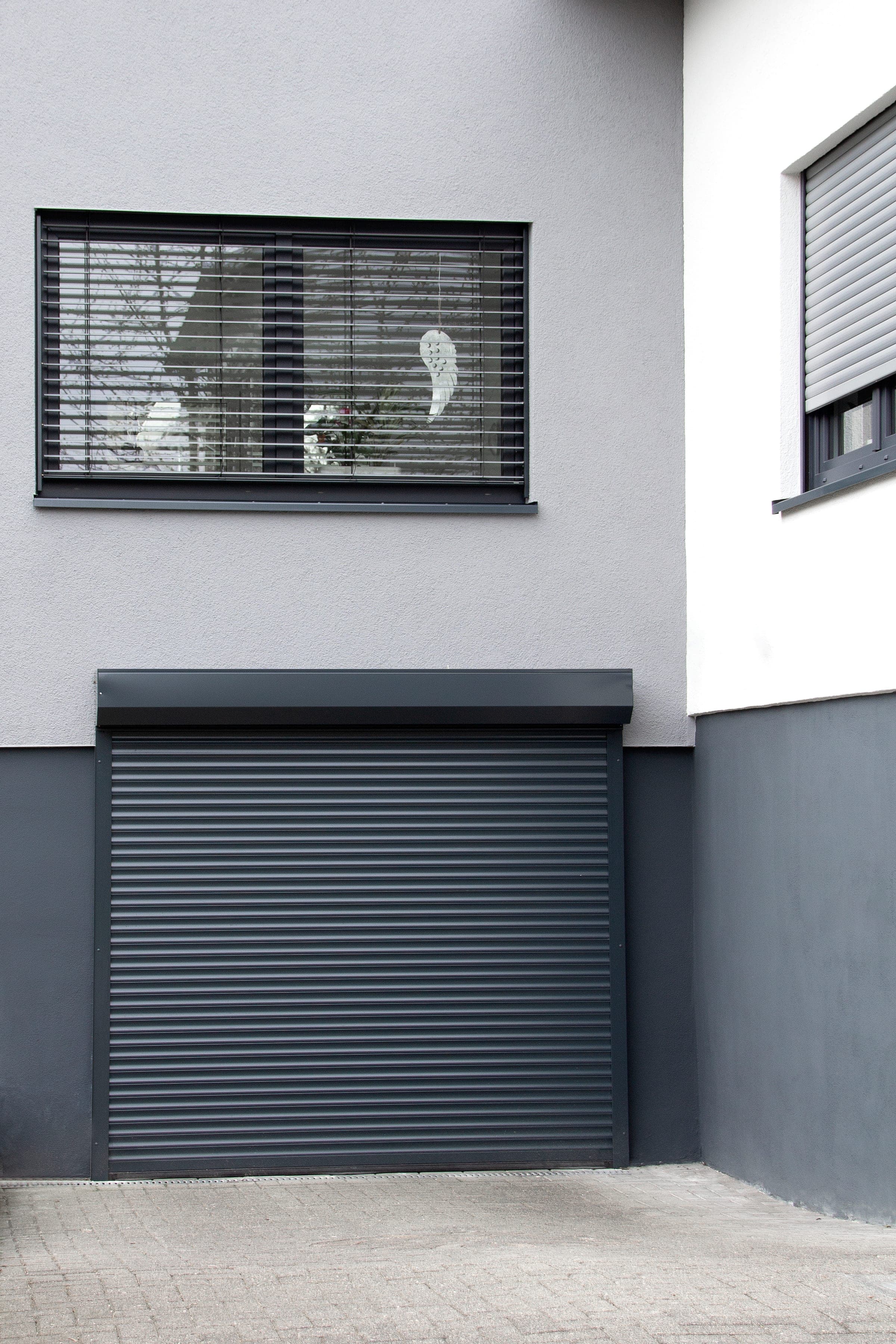 Anthrazitfarbenes Kastenrolltor an einer Hausfassade