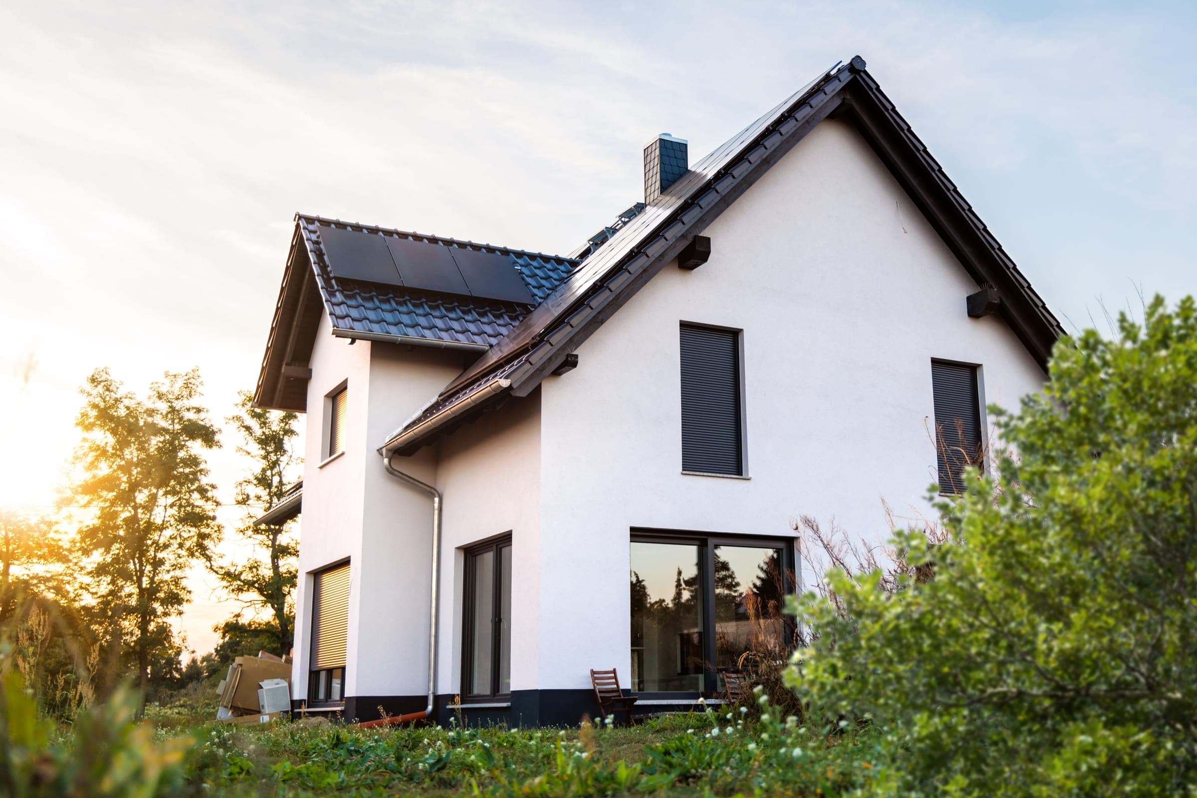 Maison neuve écoénergétique avec volets roulants et installation solaire à la tombée du jour