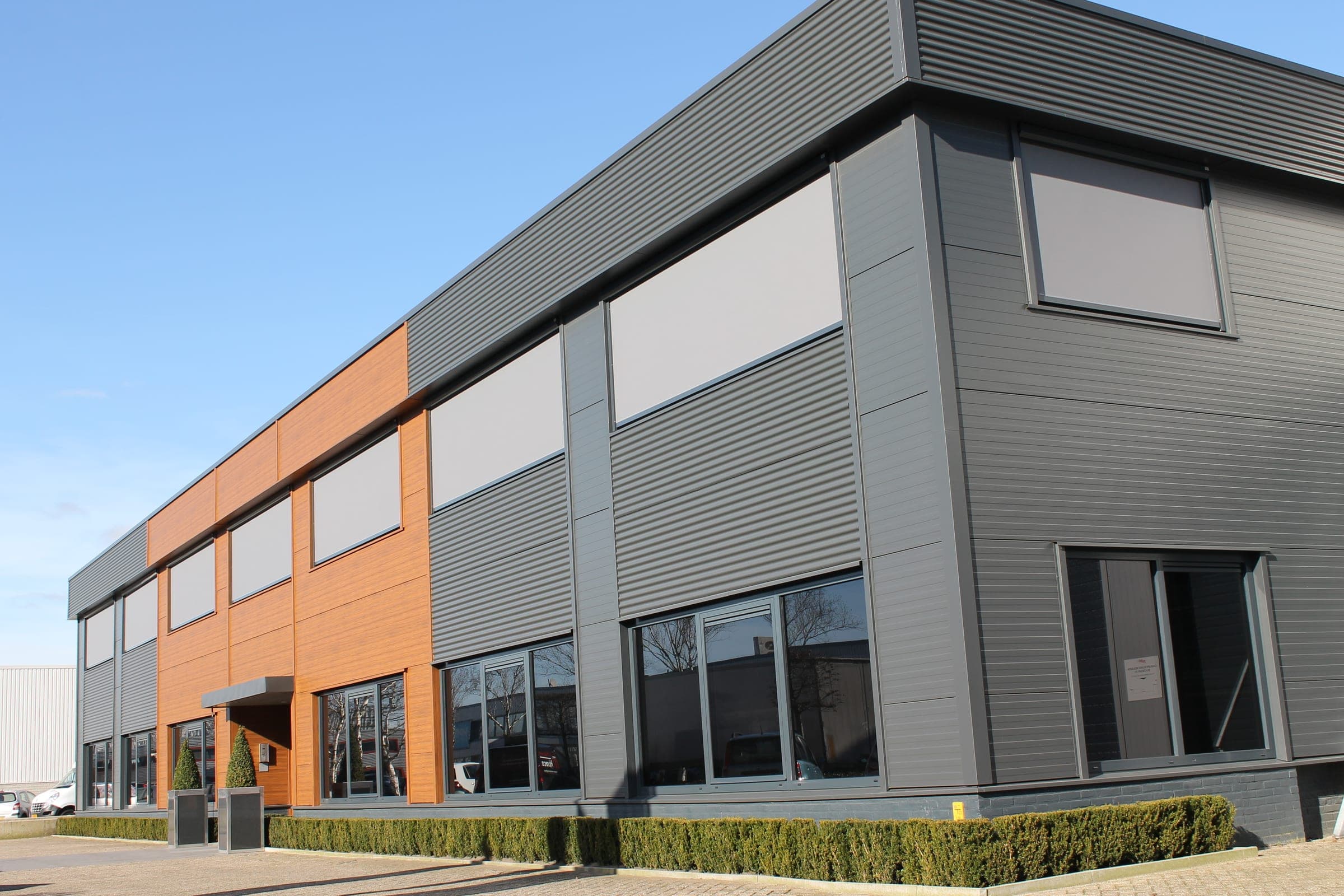 Moderne Gewerbefassade mit heruntergelassenen Alulux Unterputz-Textilscreens