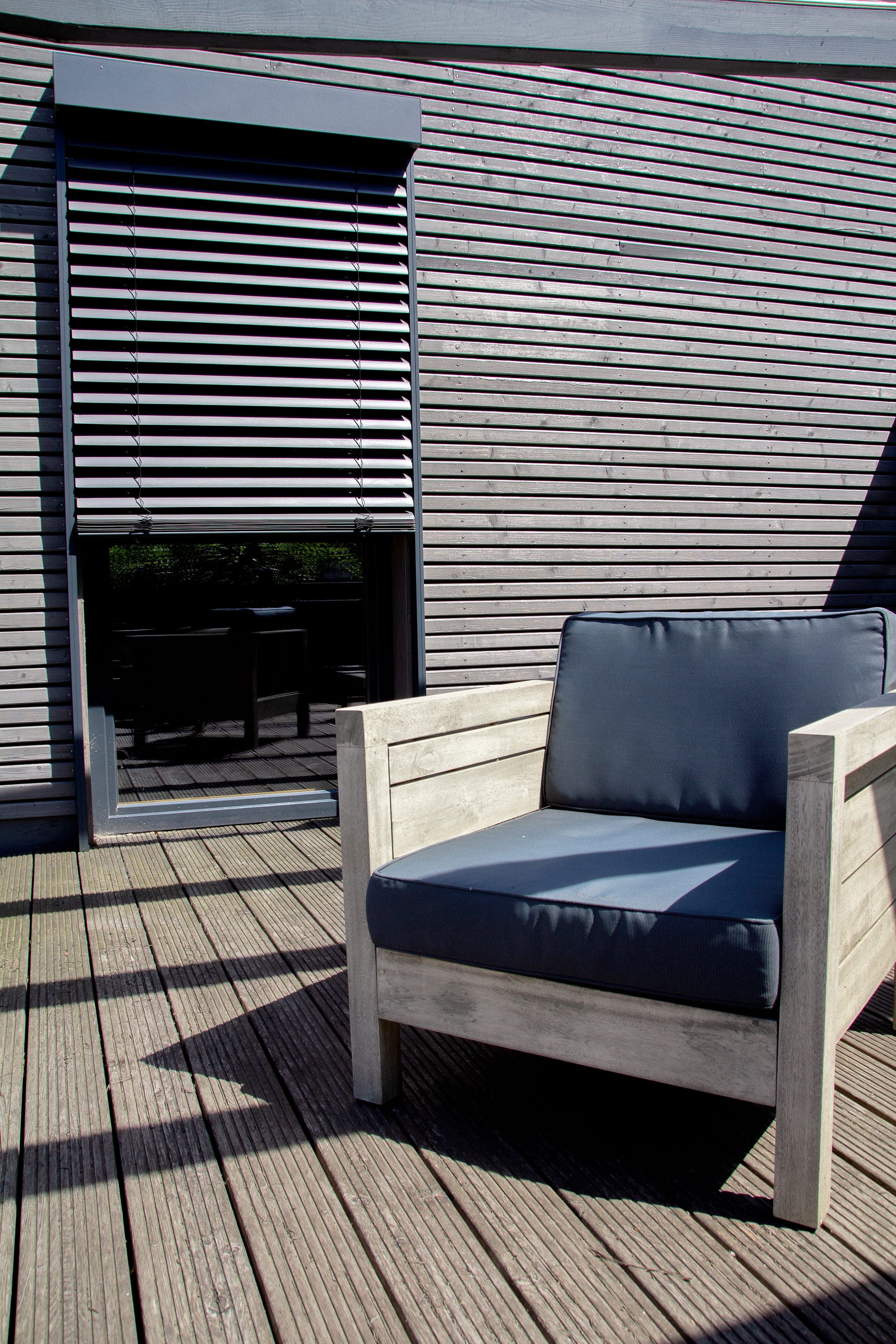ARTec-Vorbau-Raffstore halb hochgefahren auf einer sonnigen Terrasse