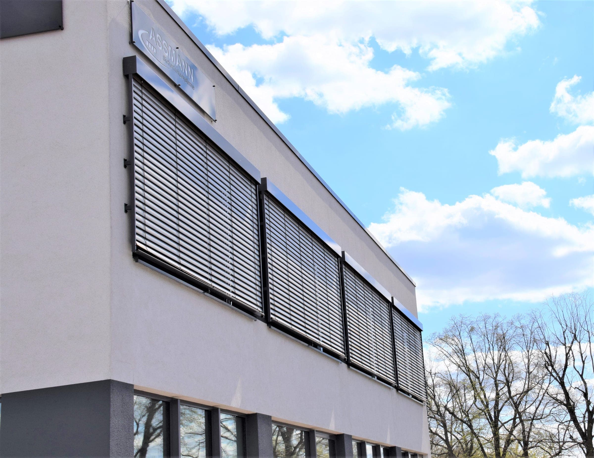 ARTec-Vorbau-Raffstore mit gekippten Aluminiumlamellen an einer Fassade