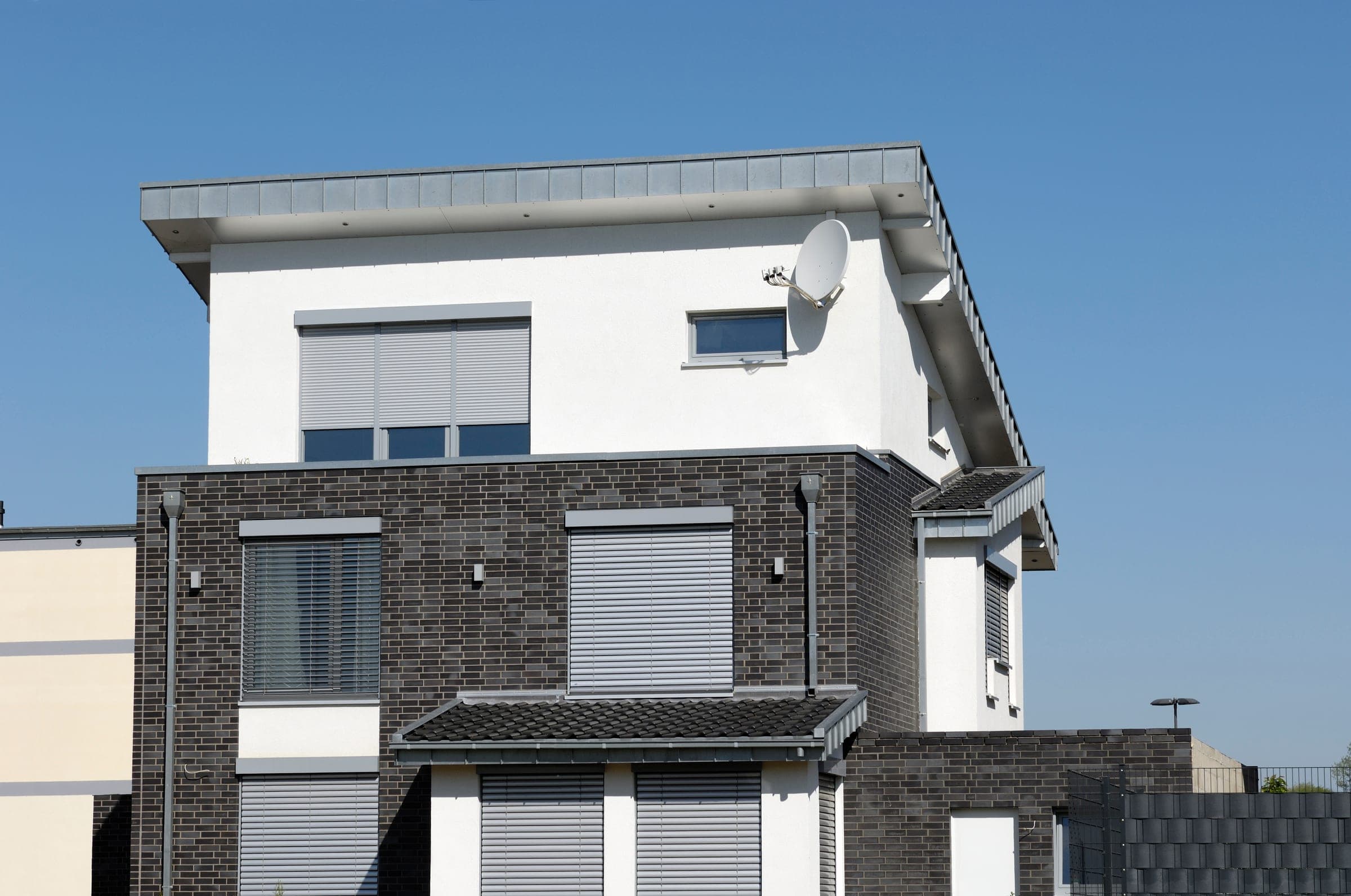 Modernes Klinkerhaus mit Alulux Raffstoren als Sonnenschutz an der Fassade
