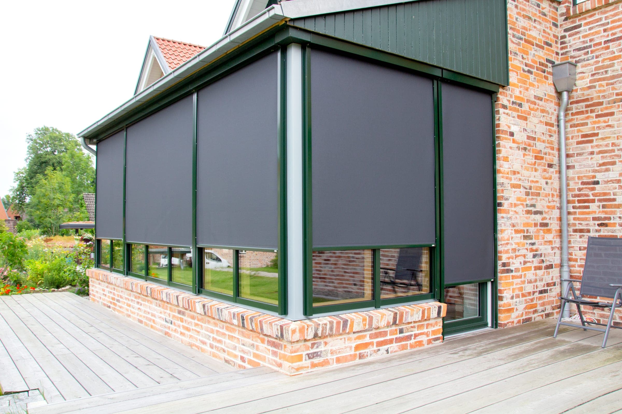 Wintergarten mit umlaufenden Alulux Textilscreens als Sonnen- und Windschutz an der Terrasse